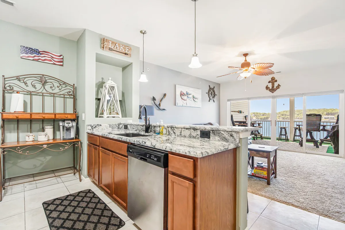 A kitchen with granite countertops, modern appliances, decorative touches, and a glimpse of the outdoors through a window or door. The space is bright and inviting, ideal for cooking and entertaining, and hints at the connection between indoor comforts and outdoor beauty.